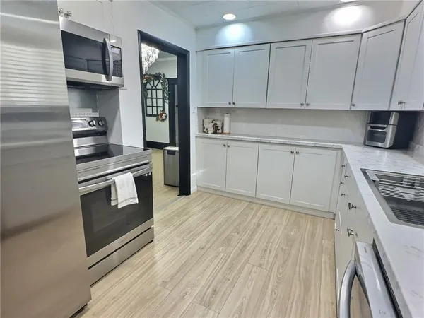 a kitchen with stainless steel appliances granite countertop a stove a sink and a refrigerator
