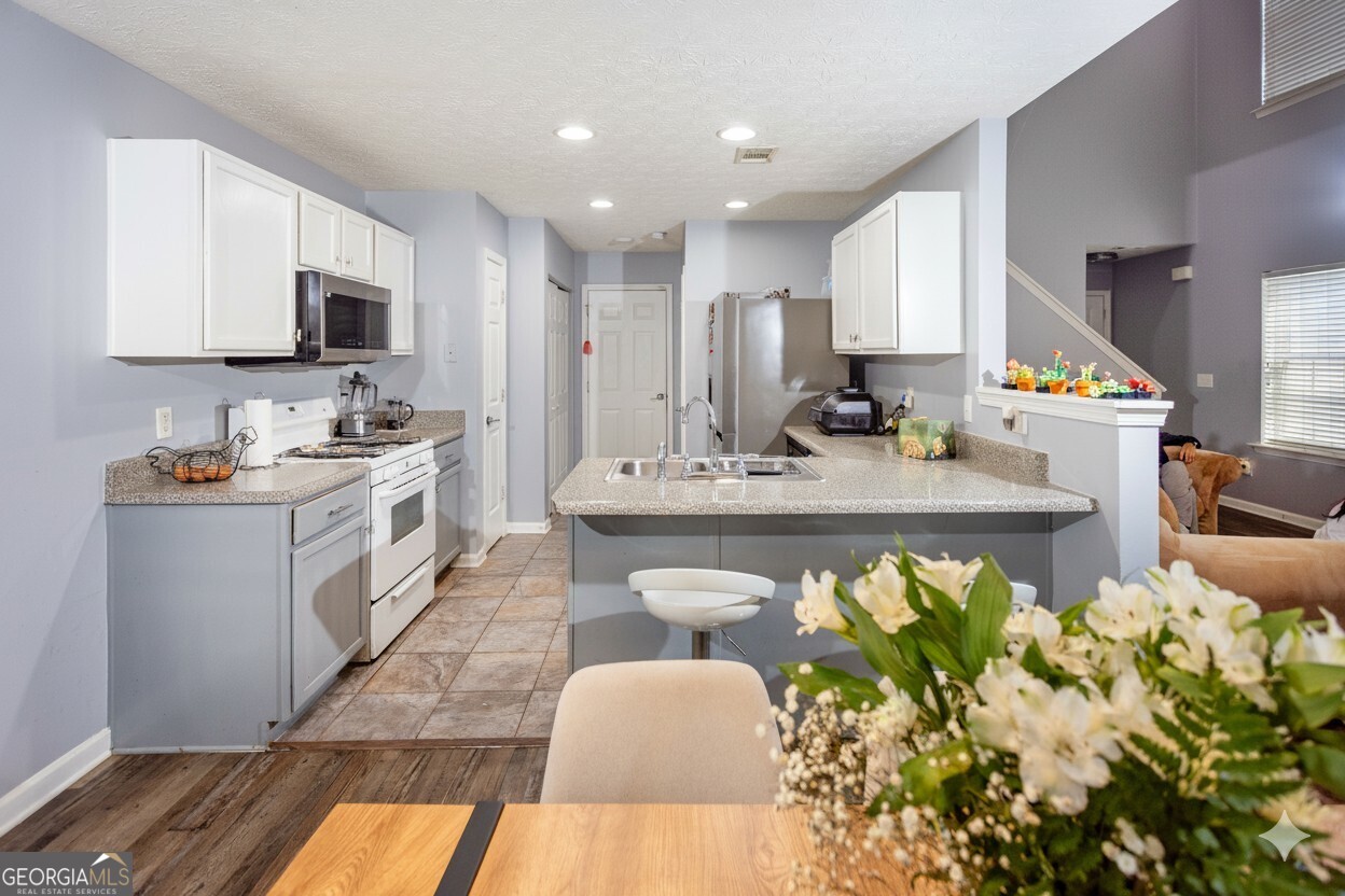 269 Silver Ridge Drive, Unit 269 Dallas, GA 30157 - Photo 12 of 34 a kitchen with stainless steel appliances kitchen island granite countertop a sink a stove a microwave a counter top space and cabinets