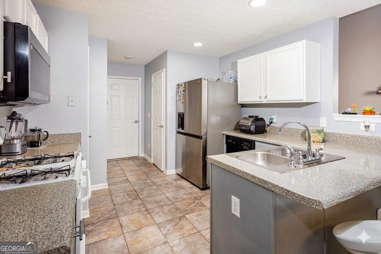 269 Silver Ridge Drive, Unit 269 Dallas, GA 30157 - Photo 15 of 34 a kitchen with stainless steel appliances a sink stove refrigerator and cabinets