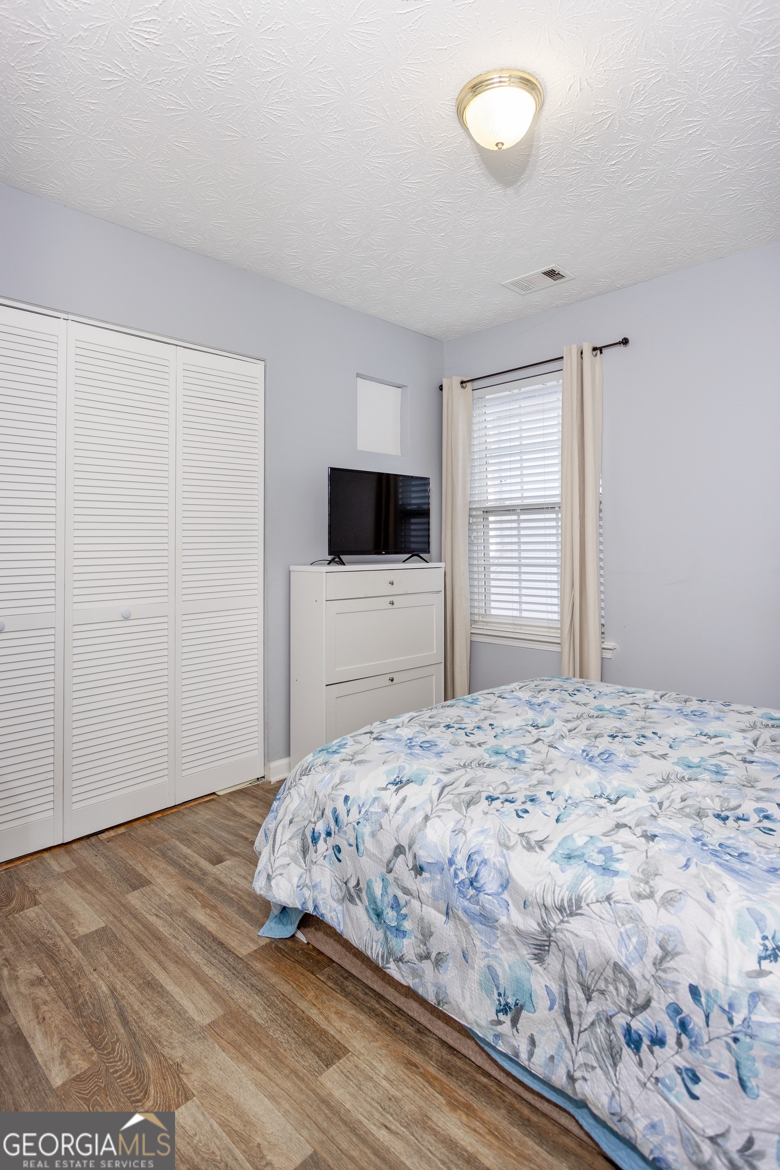 269 Silver Ridge Drive, Unit 269 Dallas, GA 30157 - Photo 27 of 34 a bedroom with a bed and a flat screen tv