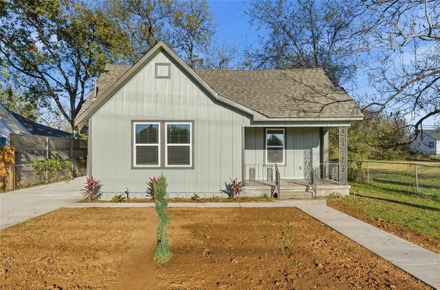 a front view of a house with a yard and potted plants