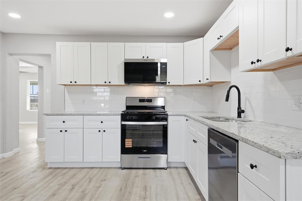 803 Garrison Street Waco, TX 76704 - Photo 7 of 16 a kitchen with white cabinets stainless steel appliances and sink