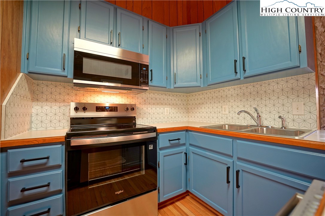 1028 Charter Hills Road Beech Mountain, NC 28604 - Photo 11 of 25 a kitchen with granite countertop cabinets stainless steel appliances and sink