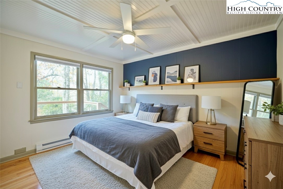 1028 Charter Hills Road Beech Mountain, NC 28604 - Photo 12 of 25 a bedroom with a large bed and a chandelier