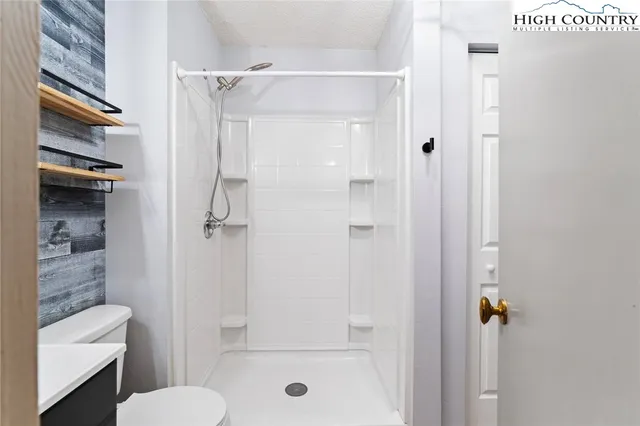 a bathroom with a shower a toilet and a shower