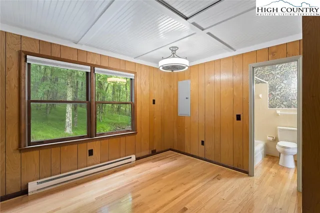 a view of empty room with wooden floor and fan