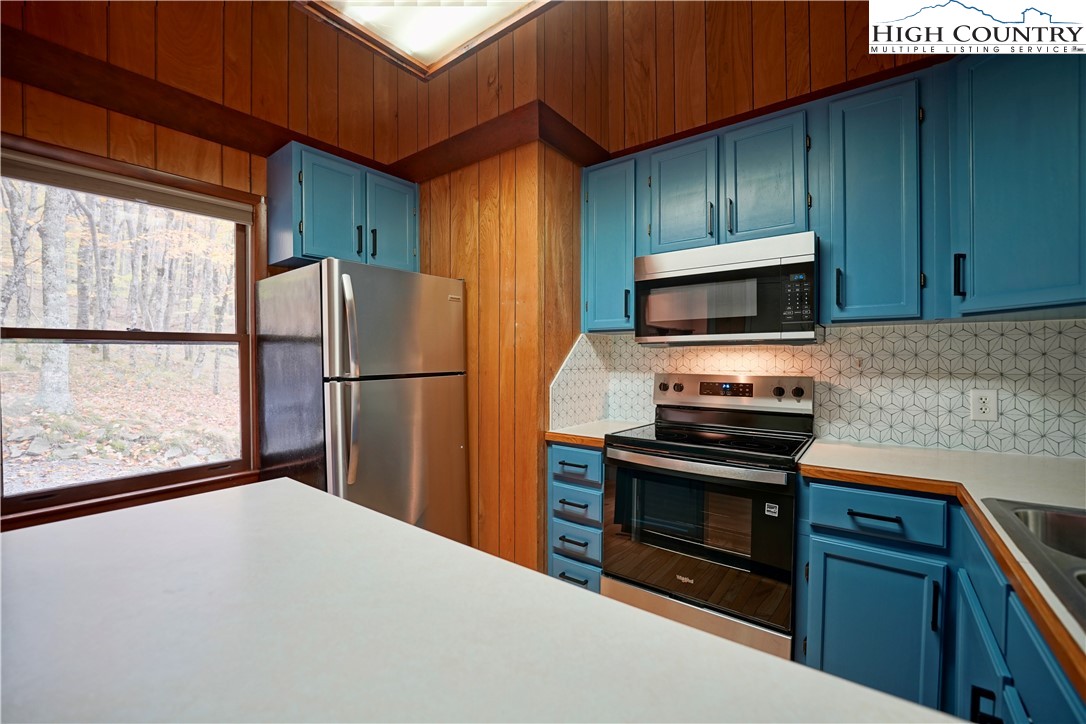 1028 Charter Hills Road Beech Mountain, NC 28604 - Photo 10 of 25 a kitchen with a refrigerator and a stove top oven