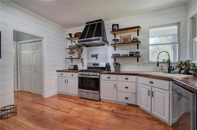 a kitchen with wooden floors white cabinets and sink