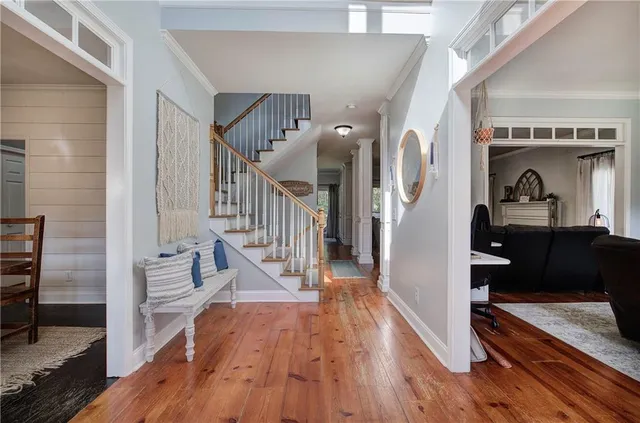 a view of a hallway with wooden floor and windows