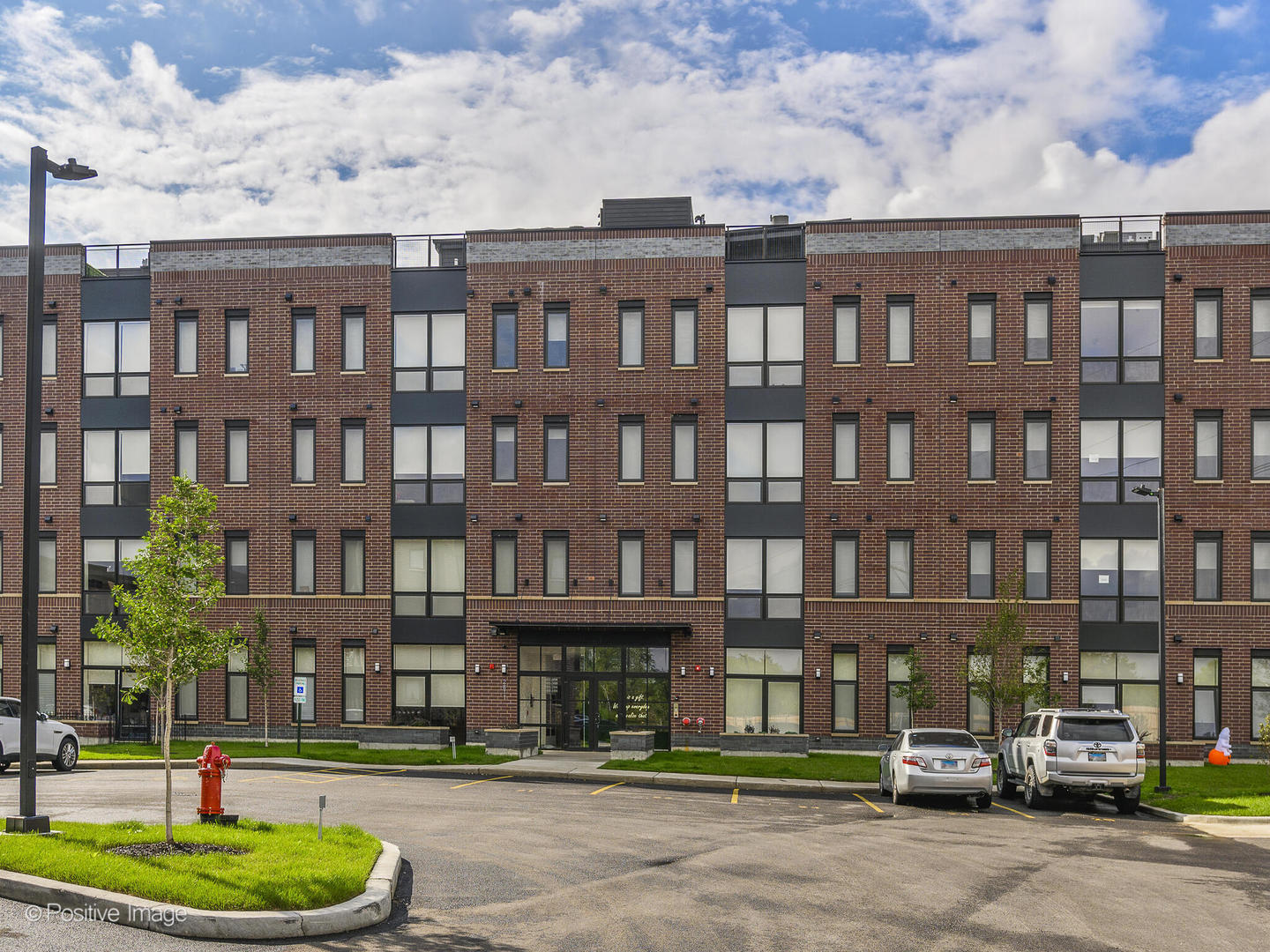 a front view of a residential apartment building with a yard