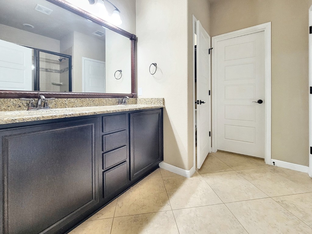 7508 Colina Vista Loop, Unit B Austin, TX 78750 - Photo 15 of 40 a bathroom with a granite countertop sink and a mirror