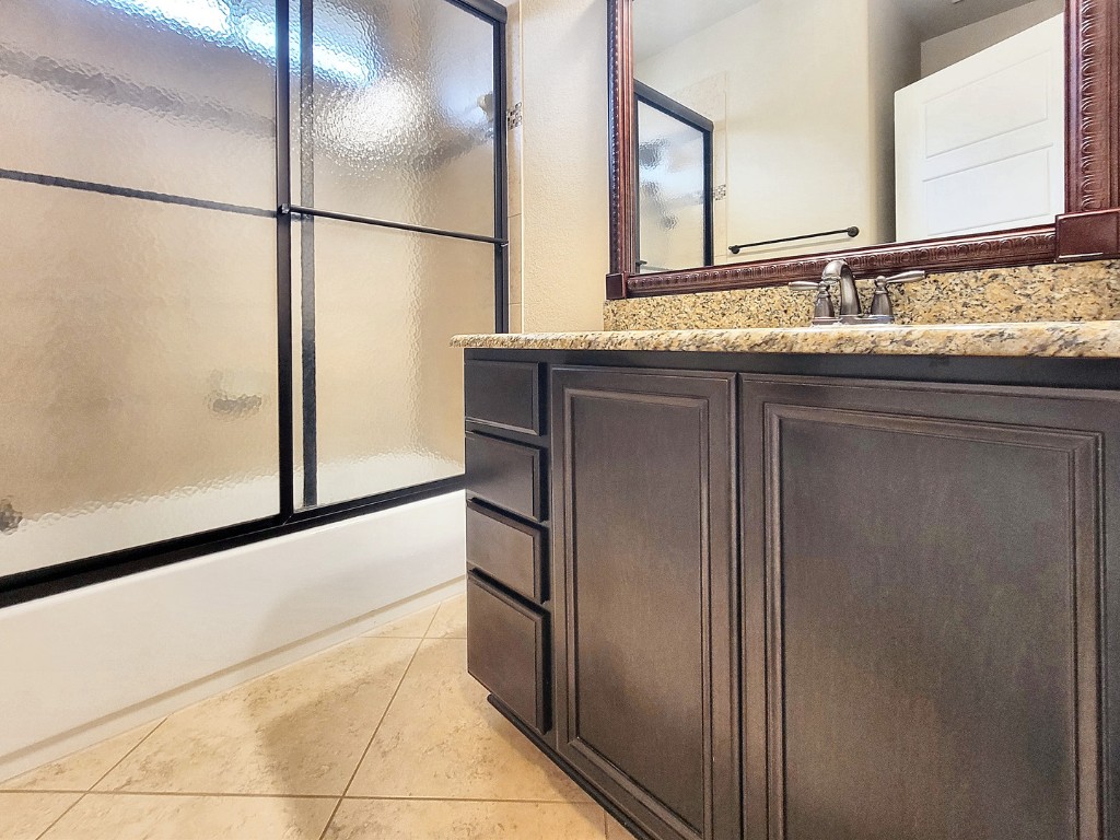7508 Colina Vista Loop, Unit B Austin, TX 78750 - Photo 23 of 40 a bathroom with a granite countertop sink and a mirror
