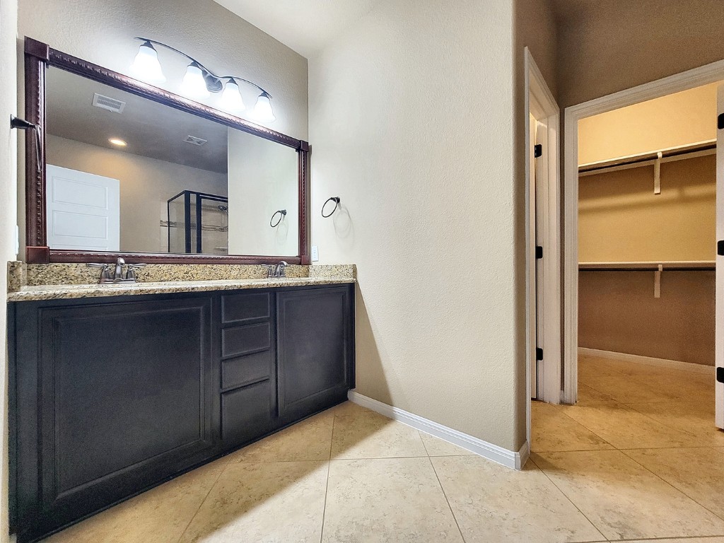 7508 Colina Vista Loop, Unit B Austin, TX 78750 - Photo 32 of 40 a bathroom with a granite countertop sink and a mirror