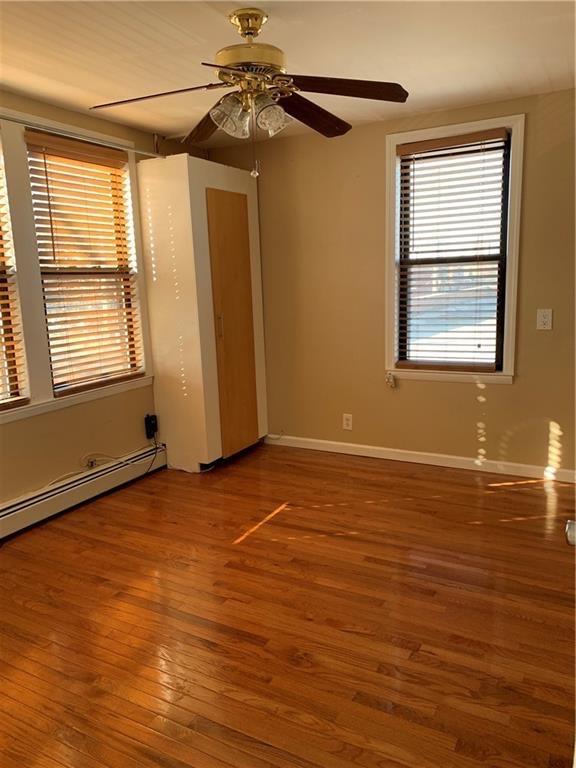 2564 Paulding Avenue Bronx, NY 10469 - Photo 3 of 14 Spare room with a baseboard radiator, wood finished floors, and a ceiling fan