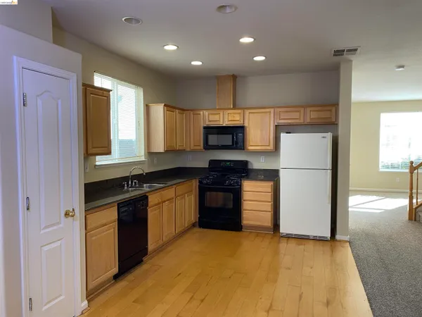 a kitchen with a refrigerator and a stove top oven