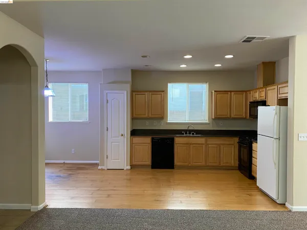 a kitchen with stainless steel appliances granite countertop a refrigerator and a stove top oven