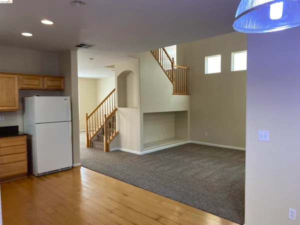 a view of a livingroom with wooden floor and a staircase