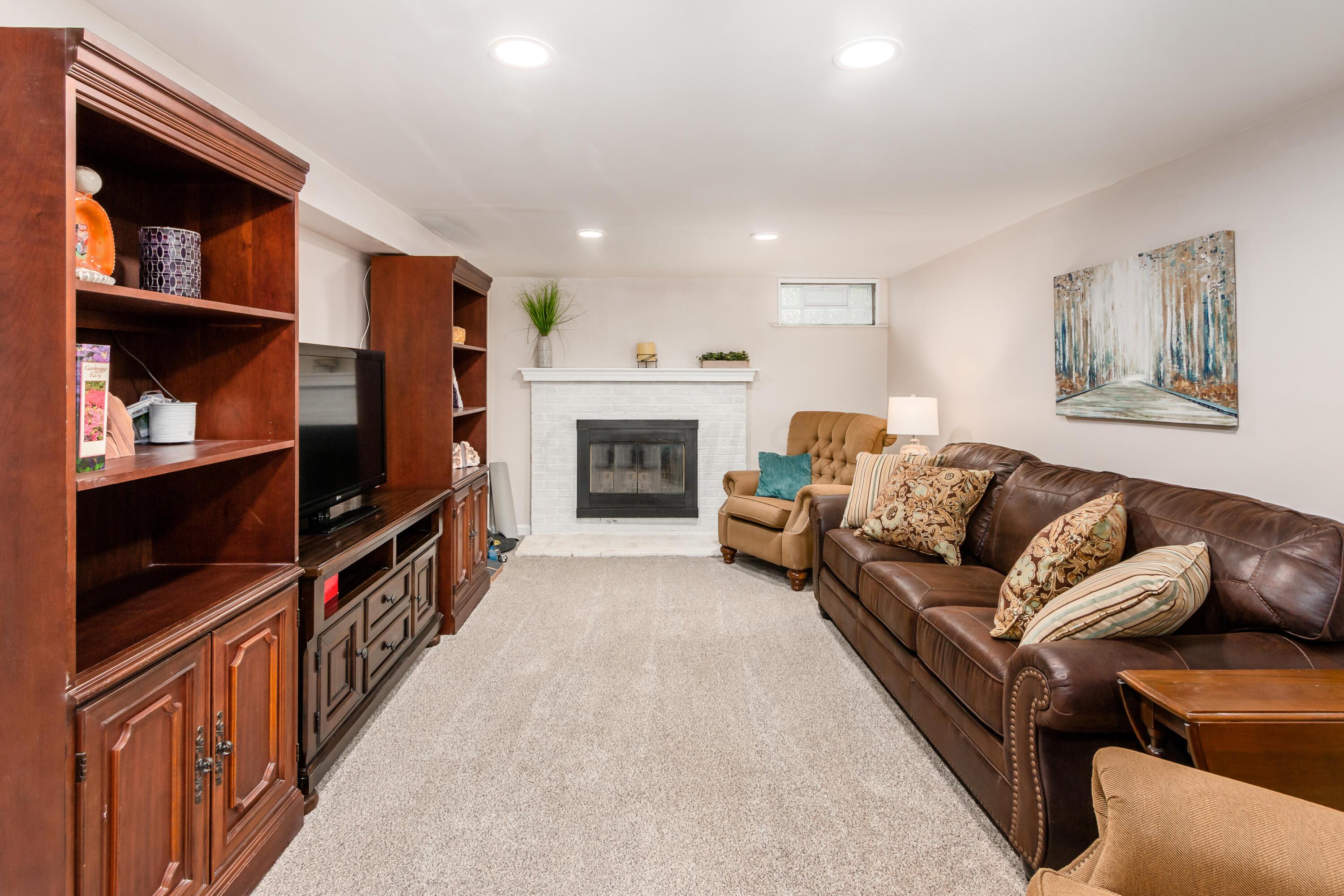 5165 Tussic St Road Westerville, OH 43082 - Photo 41 of 62 Lower level Family Room includes wood burning fireplace. Carpet, neutral paint