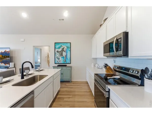 a kitchen that has a sink and a stove top oven