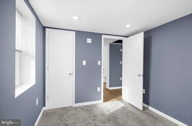 a view of hallway with a large window and chandelier fan