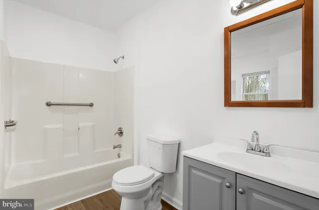 a bathroom with a granite countertop sink toilet and a mirror