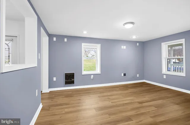 a view of an empty room with window and closet area