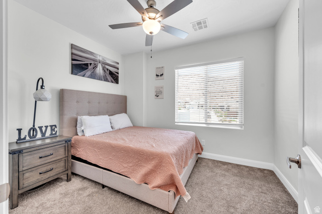 6105 Bunda Way St. George, UT 84790 - Photo 27 of 49 Neutral wall paint, ceiling fan with integrated lighting, window with blinds, light-toned carpet, and a white door with brushed nickel hardware