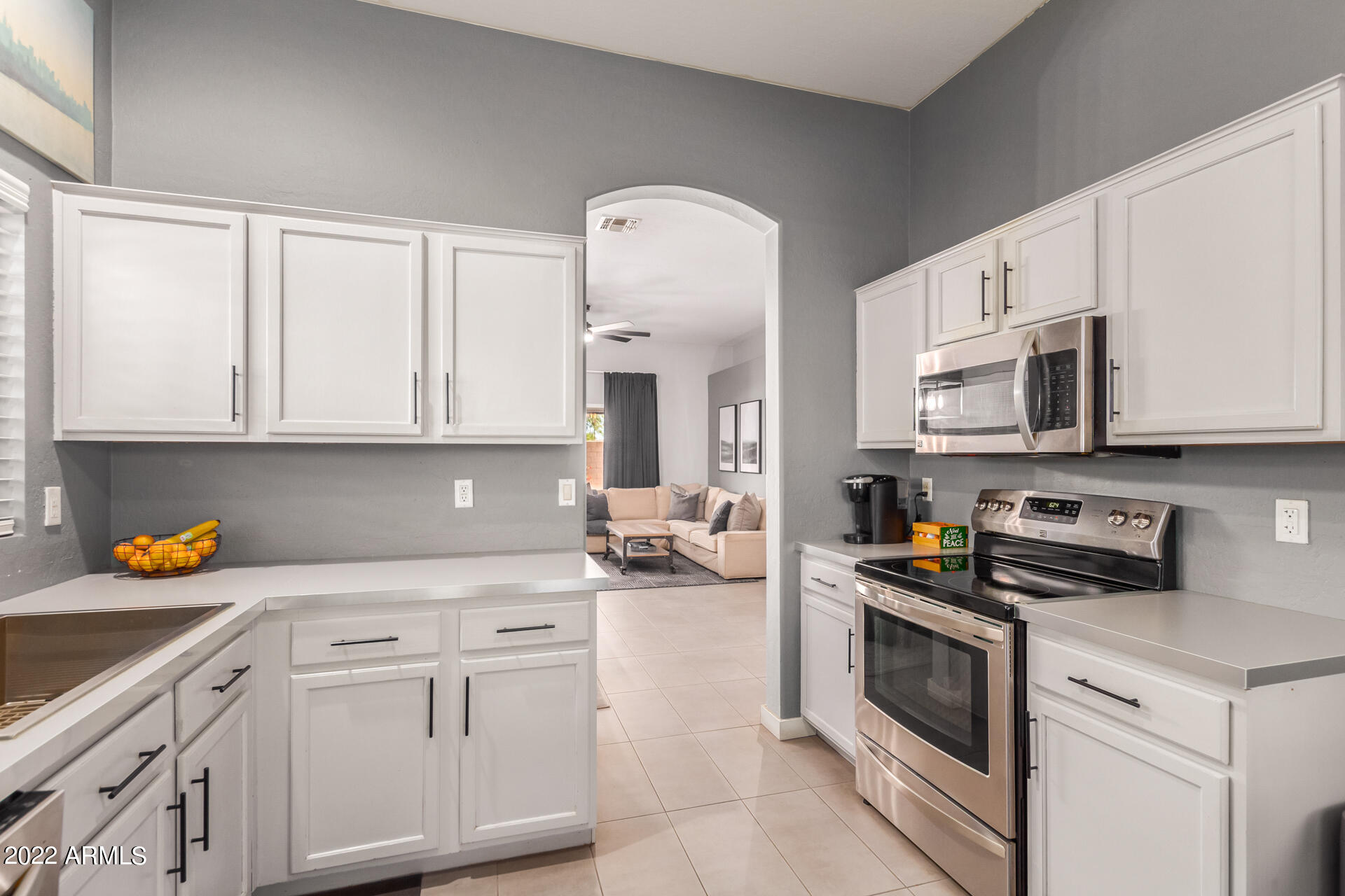 5515 South 15th Way Phoenix, AZ 85040 - Photo 15 of 28 a kitchen with stainless steel appliances granite countertop a sink dishwasher stove and white cabinets with wooden floor