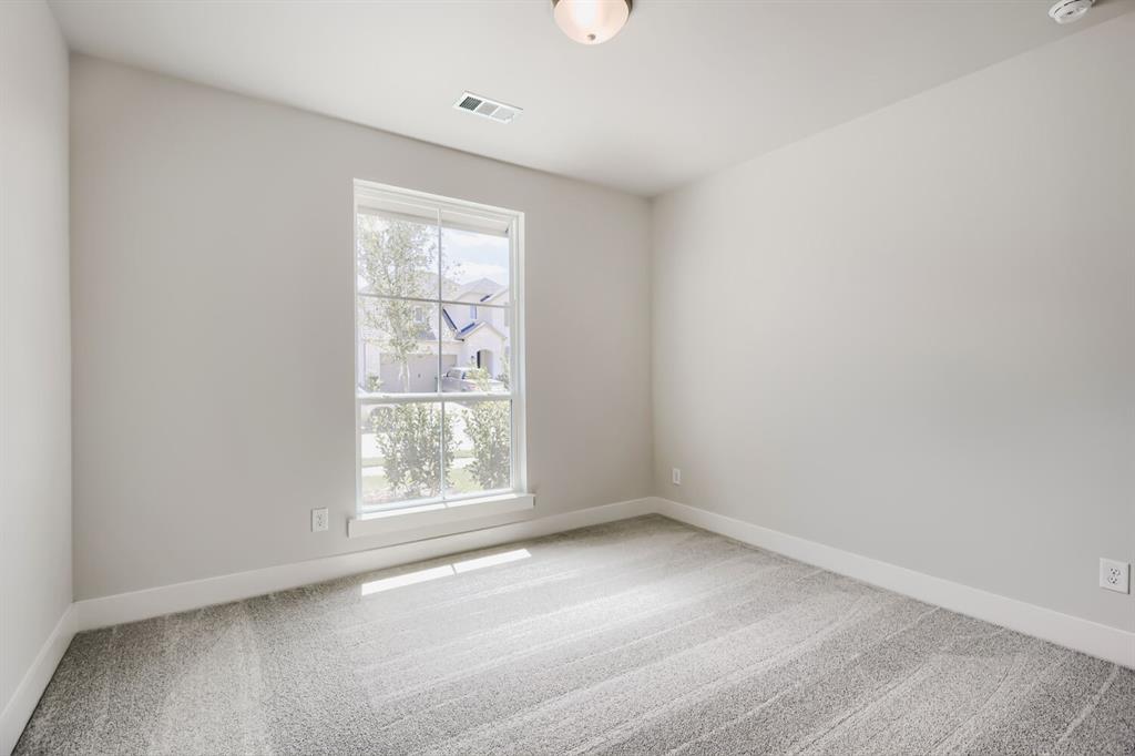 4407 Windy Point Road Oak Point, TX 75068 - Photo 12 of 27 Neutral-toned room with a large window, light gray carpeting, crisp white baseboards, and a flush-mount ceiling light fixture