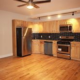 a kitchen with stainless steel appliances granite countertop a refrigerator and a stove top oven