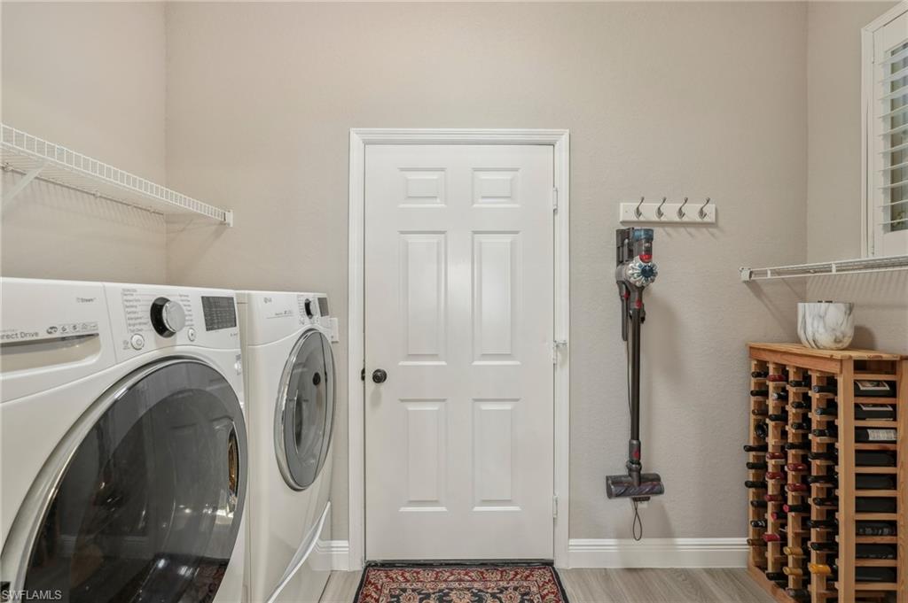 3653 Periwinkle Way Naples, FL 34114 - Photo 22 of 49 Laundry room with wood finished floors and washer and clothes dryer