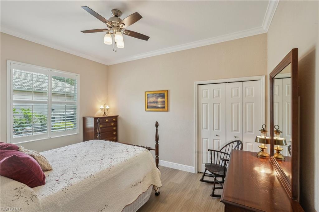 3653 Periwinkle Way Naples, FL 34114 - Photo 24 of 49 Bedroom with ornamental molding, a closet, light wood-type flooring, and a ceiling fan