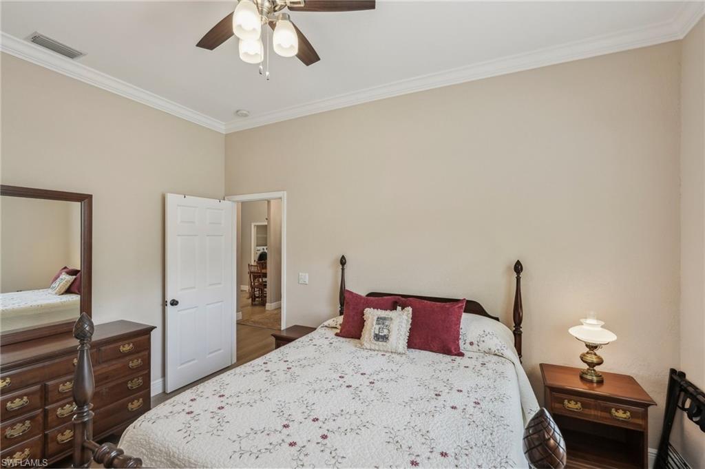 3653 Periwinkle Way Naples, FL 34114 - Photo 25 of 49 Bedroom with crown molding, dark wood-style flooring, and a ceiling fan