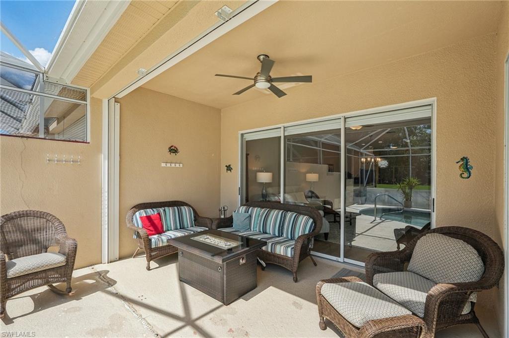 3653 Periwinkle Way Naples, FL 34114 - Photo 30 of 49 View of patio featuring glass enclosure, ceiling fan, and an outdoor living space with a fire pit