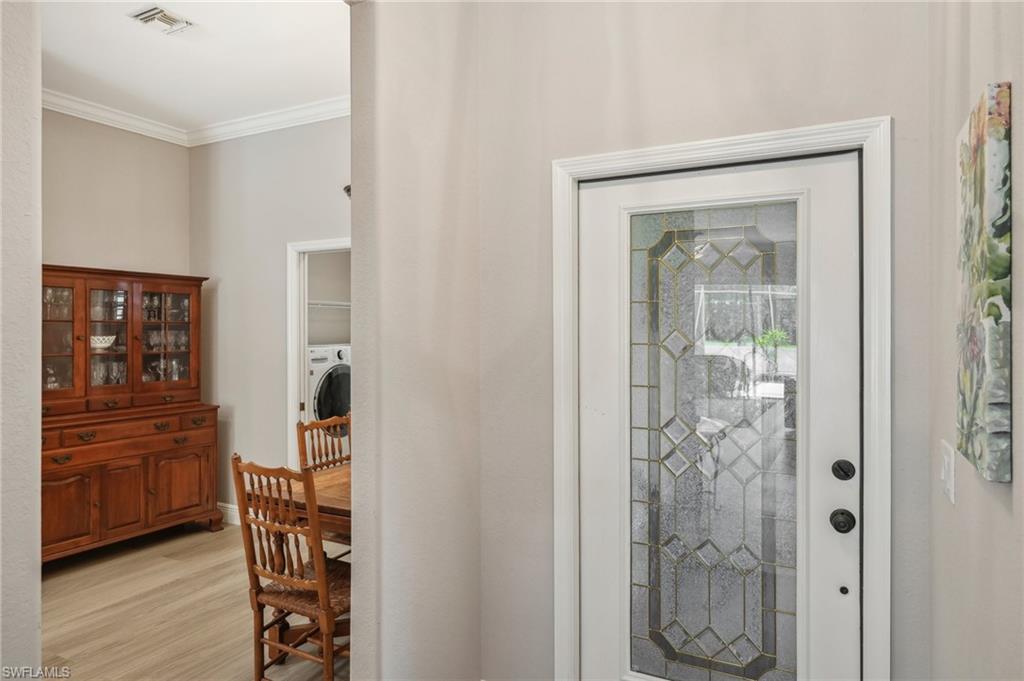 3653 Periwinkle Way Naples, FL 34114 - Photo 4 of 49 Foyer with ornamental molding, light wood-style floors, and washer / dryer