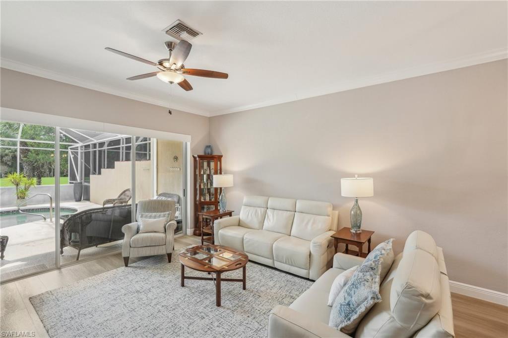 3653 Periwinkle Way Naples, FL 34114 - Photo 6 of 49 Living room featuring wood finished floors, crown molding, a ceiling fan, and a sunroom