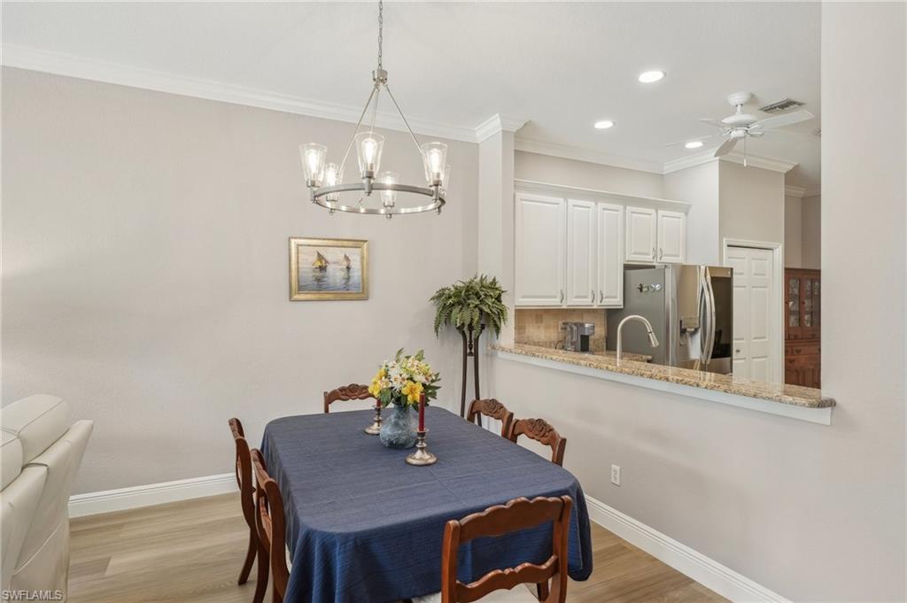 3653 Periwinkle Way Naples, FL 34114 - Photo 10 of 49 Dining room featuring crown molding, light wood-style floors, recessed lighting, a ceiling fan, and a chandelier