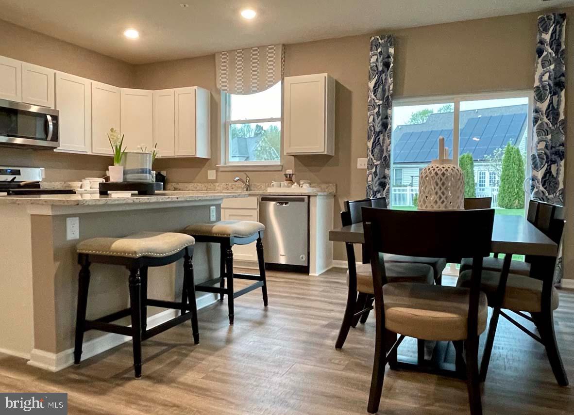 1145 Wintermead Loop Salisbury, MD 21801 - Photo 21 of 51 a kitchen with a table chairs refrigerator and cabinets