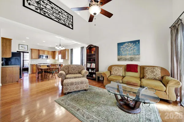 a living room with furniture and a view of kitchen