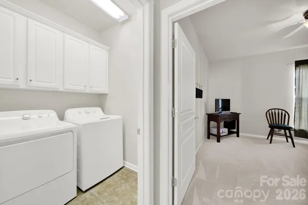 a view of washer and dryer with bathroom in the background