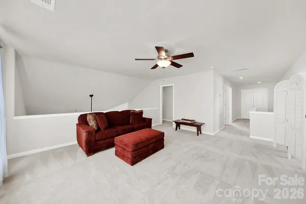a living room with furniture and a ceiling fan