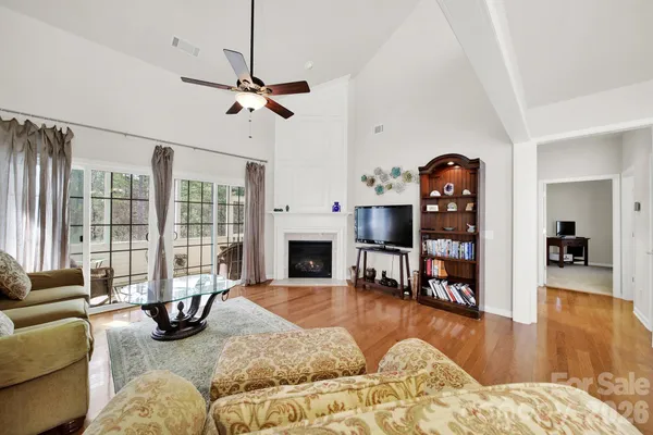 a living room with fireplace furniture and a floor to ceiling window