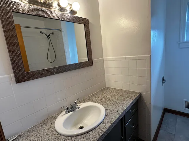 a bathroom with a granite countertop sink and a mirror