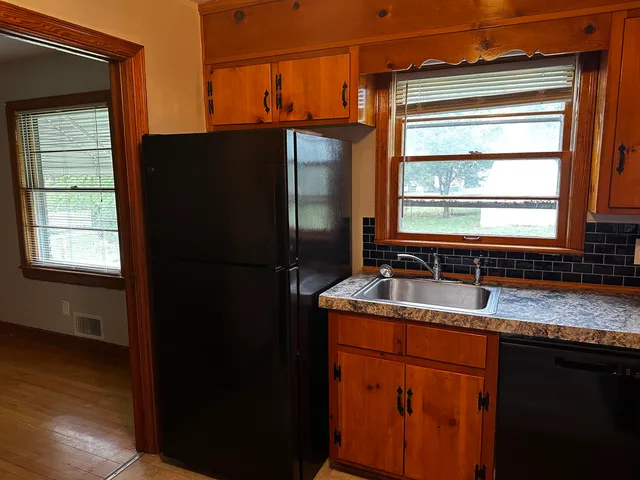 a kitchen with granite countertop cabinets stainless steel appliances a sink and a window