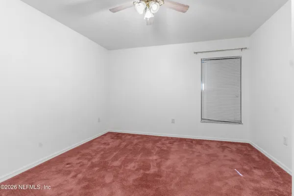 an empty room with a chandelier fan