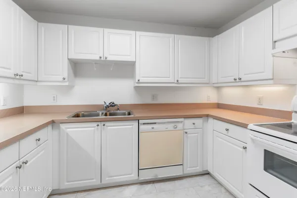 a kitchen with white cabinets and white appliances