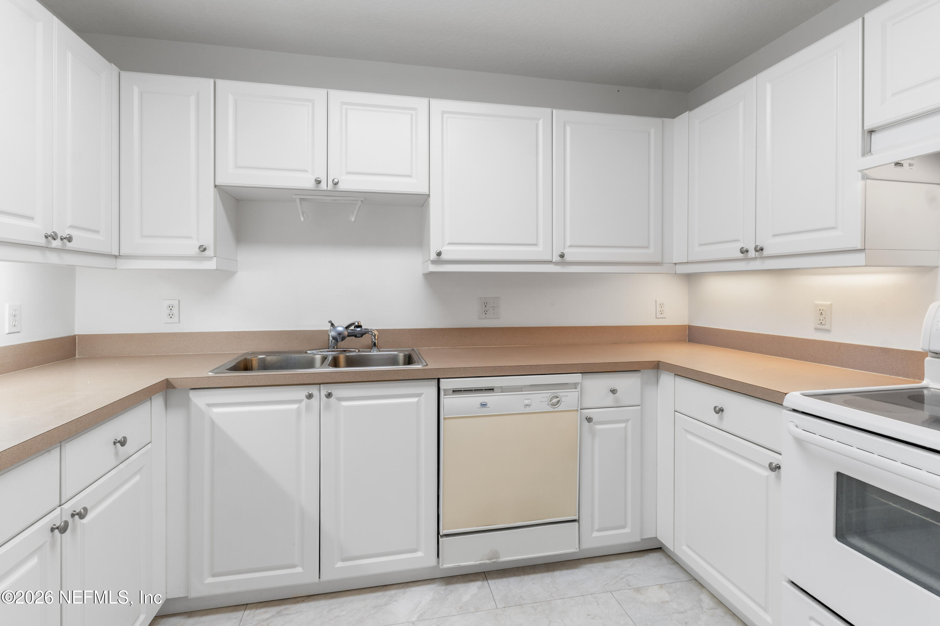 1022 Foster Road Sebastian, FL 32958 - Photo 9 of 30 a kitchen with white cabinets and white appliances