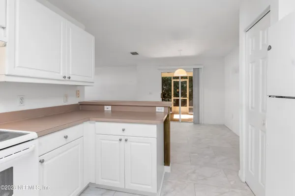 a kitchen with granite countertop white cabinets and window