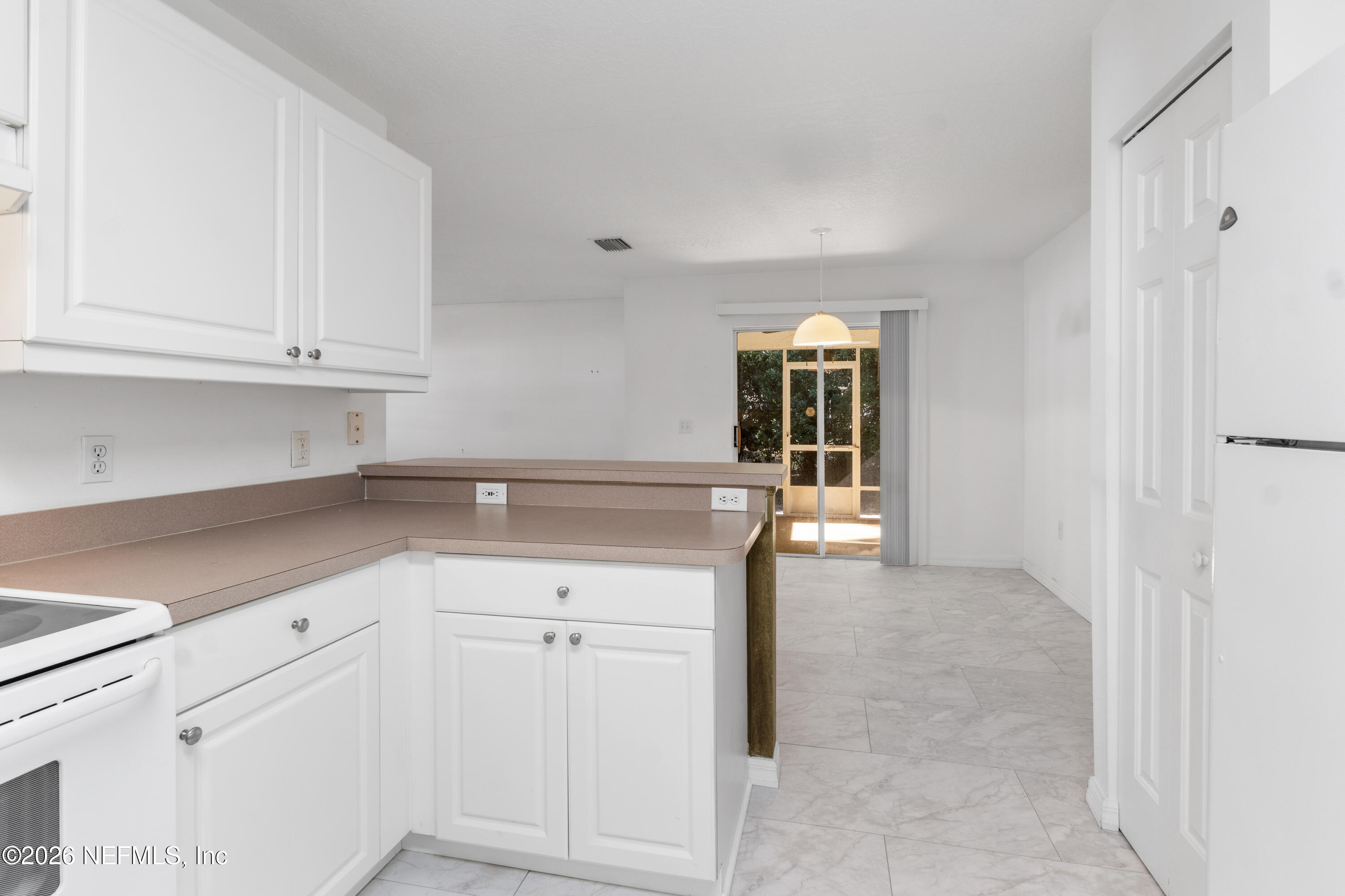1022 Foster Road Sebastian, FL 32958 - Photo 10 of 30 a kitchen with granite countertop white cabinets and window