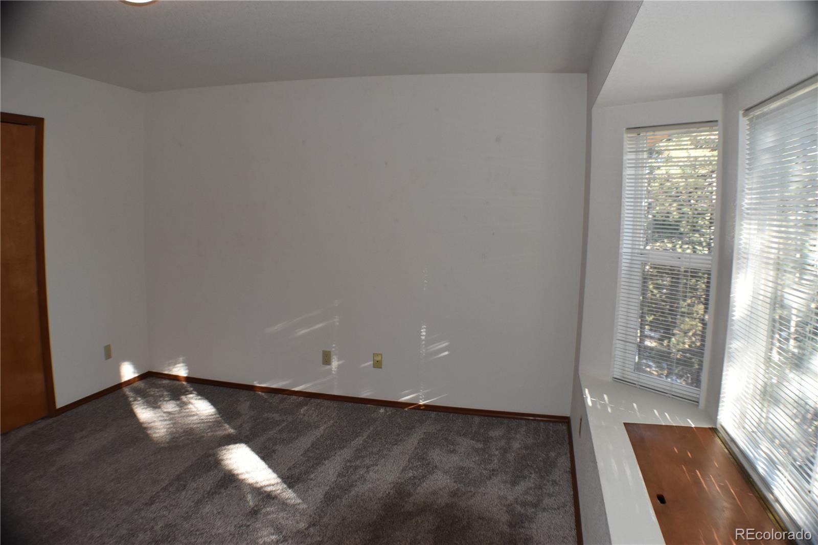 14540 Rosholt Loop Colorado Springs, CO 80921 - Photo 35 of 50 an empty room with wooden floor and windows